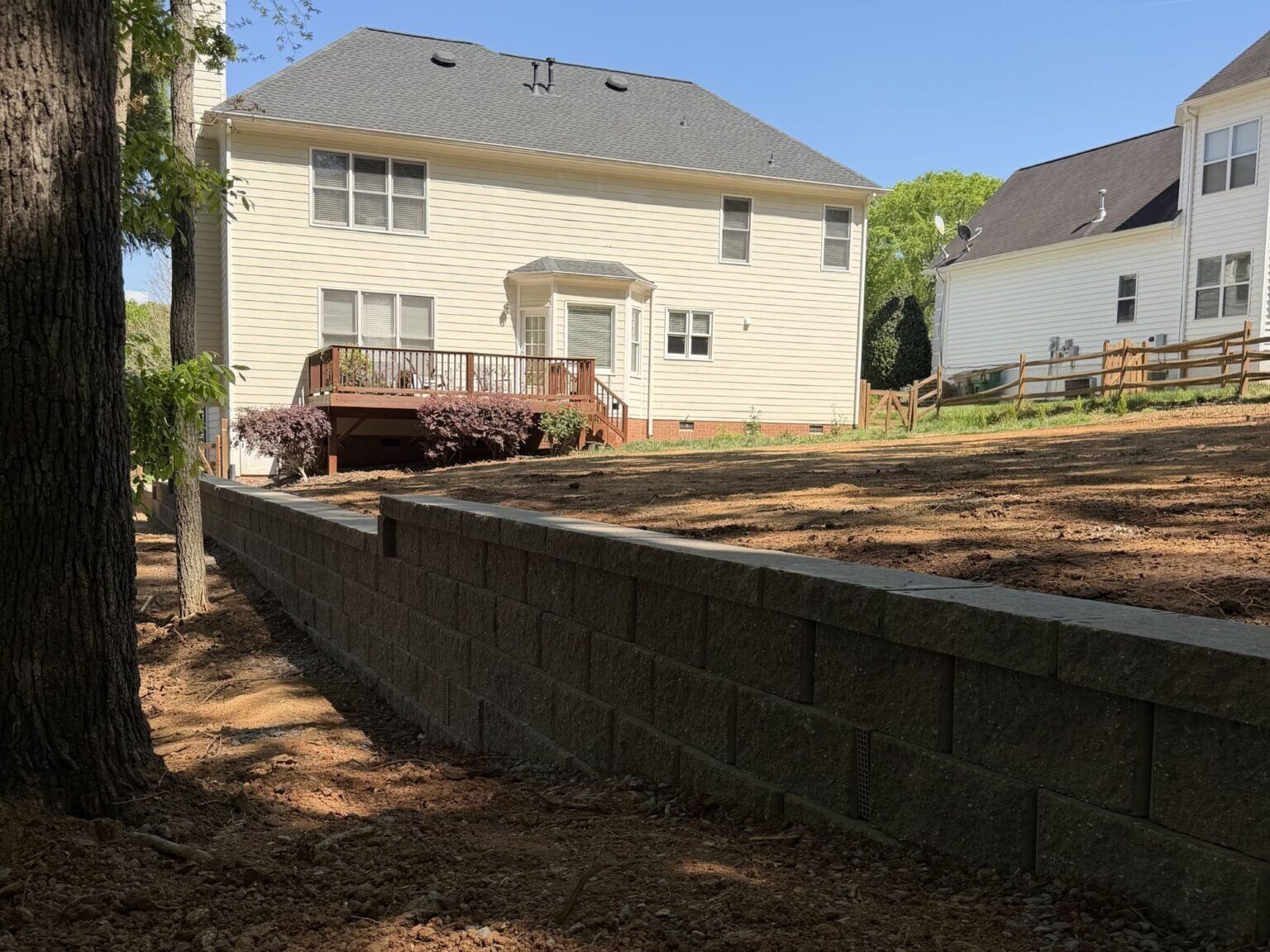 Ridgeline Restoration - Project 1 Dark charcoal retaining wall and graded backyard at the Ridgeline Restoration project in Charlotte